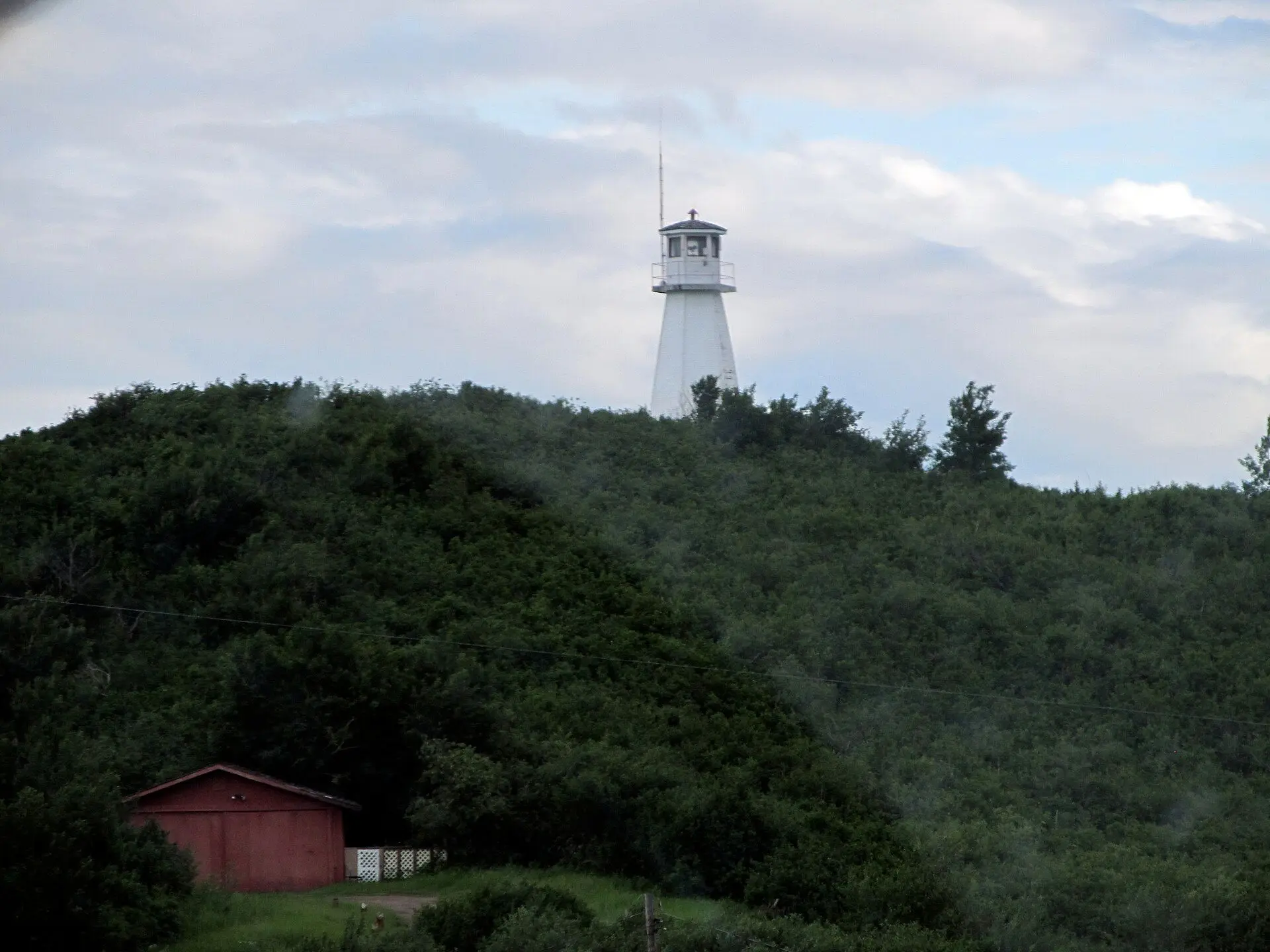 Cochin Lighthouse above the wooded hill